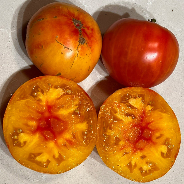 Two whole and two halved pineapple tomatoes on a light background with a label indicating 'Pineapple Rose'.